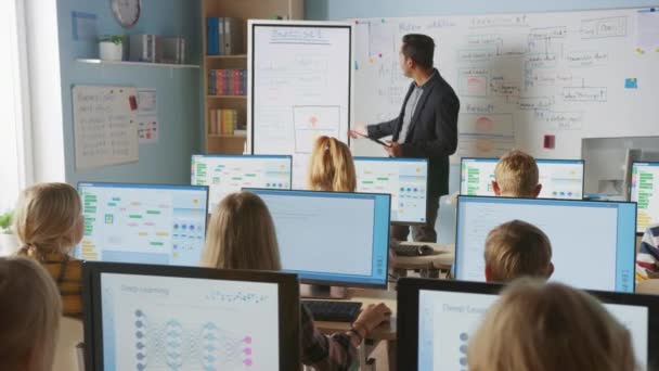 Clase de Ciencias de la Computación de la Escuela Primaria: El maestro utiliza la tableta digital, explica la lección a diversos grupos de niños inteligentes. Niños que reciben educación moderna, aprenden seguridad en Internet, programación de software — Vídeo de stock