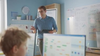 Okul Sınıfı: Coşkulu ve Motivasyonlu Öğretmenin Dijital Tablet Bilgisayarı Kullanarak Portresi Akıllı Çocuklara Ders Açıklıyor. Modern eğitim alan öğrenciler. Sadece Öğretmen