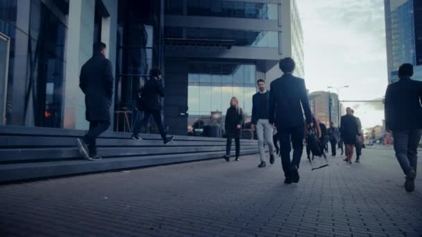 Dirigenti d'ufficio e uomini d'affari si spostano per lavorare al mattino o da ufficio in una giornata nuvolosa a piedi. I pedoni sono intelligenti vestiti con disinvoltura. Persone di successo in possesso di smartphone . — Video Stock