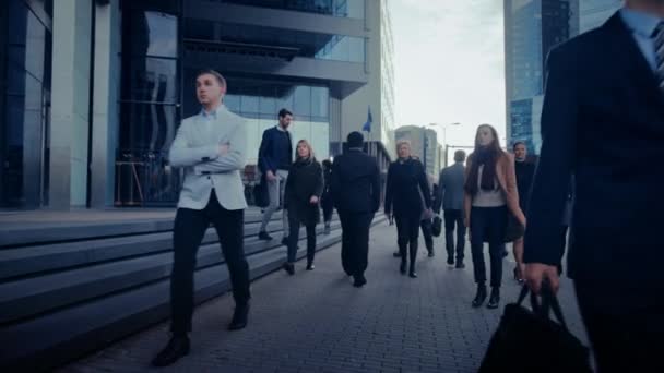 オフィスマネージャーやビジネスの人々は、午前中に働くために通勤または徒歩で曇りの日にオフィスから。歩行者はスマートカジュアルに服を着ています。成功した人々は、スマートフォンを保持. — ストック動画