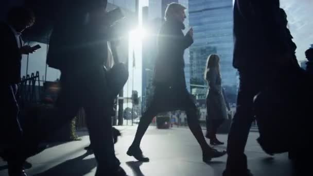 Los gerentes de oficina y los empresarios viajan al trabajo por la mañana o desde la oficina en un día soleado a pie. Los peatones están vestidos con elegancia. Gente exitosa sosteniendo teléfonos inteligentes. Filmación de Arriba . — Vídeos de Stock