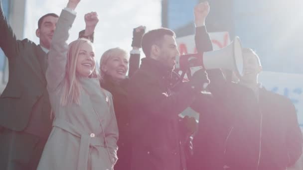 Wielokulturowi menedżerowie biur i biznesmeni pikietujący poza ulicą. Mężczyźni i kobiety krzyczą o sprawiedliwość, trzymają megafon, pikiety i plakaty. Strajk gospodarczy. — Wideo stockowe