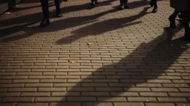 Bir İşadamının Ayakla Yürüyen Ofis 'e Gidişinin Yakın Bacak Çekimi. Yöneticiler ve iş adamları kalabalık bir yaya caddesinde yürürler. İnsanlar şık giyinmişti. Sıcak Işık.