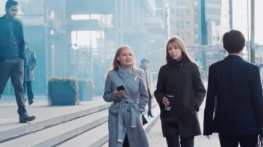 Çeşitli ve Çok Kültürlü Büro Yöneticileri ve İş Adamları Sabah İşe İşe Dönüş ya da Ayağında Güneşli Bir Gün Ofisi 'nden. İki Kadın Ofise Giderken Konuşuyor.