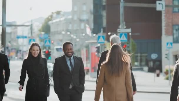 Divers gestionnaires de bureau et gens d'affaires multiculturels se rendent au travail le matin ou du bureau par une journée ensoleillée à pied. Femmes et hommes parlent et sourient sur le chemin du bureau . — Video