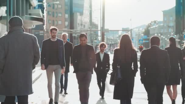 Diverse en multiculturele Office Managers en Business People pendelen 's ochtends naar het werk of vanuit kantoor op een zonnige dag te voet. Voetgangers zijn slim, casual gekleed. Mensen die smartphones gebruiken. — Stockvideo