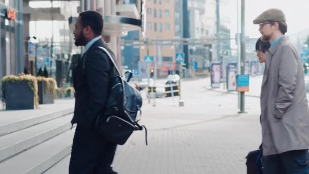 多様で多文化的なオフィスマネージャーやビジネスの人々は、午前中に仕事をするか、徒歩で晴れた日にオフィスから通勤します。歩行者はスマートカジュアルに服を着ています。スマートフォンを使う人. — ストック動画