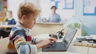 Genç Öğrenci, Robot Mühendisliği Sınıfı için Dizüstü bilgisayar kullanıyor. Teknoloji ile çalışan yetenekli parlak çocukların olduğu ilköğretim okulu bilim sınıfı.