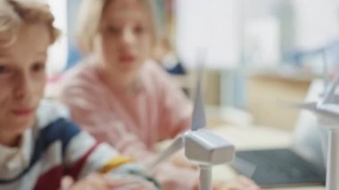 Liseli kız ve okul çocuğu, Yeşil Çevre ve Yenilenebilir Enerji hakkında bilgi edinmek için Küçük Rüzgar Türbinleri Prototipleri üzerinde çalışıyorlar. Teknoloji üzerine çalışan çocukların olduğu bir bilim sınıfı. STEM Eğitimi