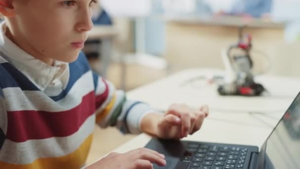 Smart Schoolboy utiliza el ordenador portátil para programar software para la clase de ingeniería de robótica. Aula de Ciencias de la Escuela Primaria con Niños Brillantes Dotados Trabajando con Tecnología — Vídeos de Stock