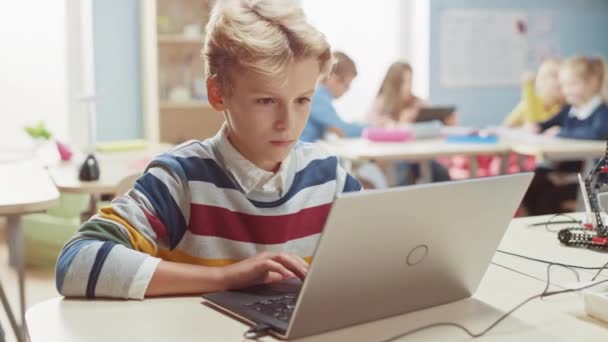 Smart Schoolboy utiliza el ordenador portátil para programar software para la clase de ingeniería de robótica. Aula de Ciencias de la Escuela Primaria con Niños Brillantes Dotados Trabajando con Tecnología — Vídeo de stock