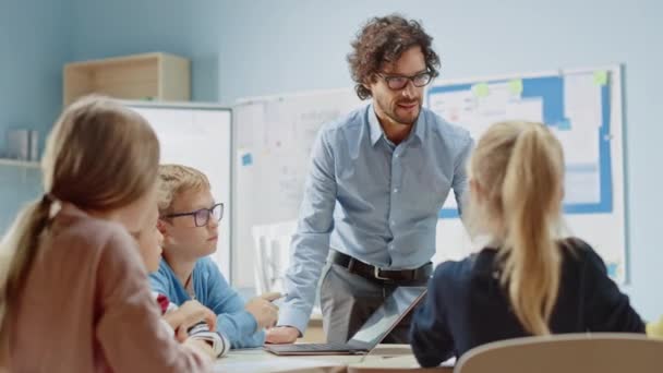 Nadšený učitel vysvětluje lekci pro třídu plnou pestrých dětí, vede třídu s energickou diskusí. In Elementary School Group of Smart Multiethnic Kids Learn New Things — Stock video