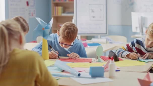 Basisschool Arts & Crafts Class: diverse groep slimme kinderen veel plezier op een handwerk project, met behulp van kleurrijk papier, schaar en lijm om Eco-vriendelijke huis te bouwen met windturbine — Stockvideo
