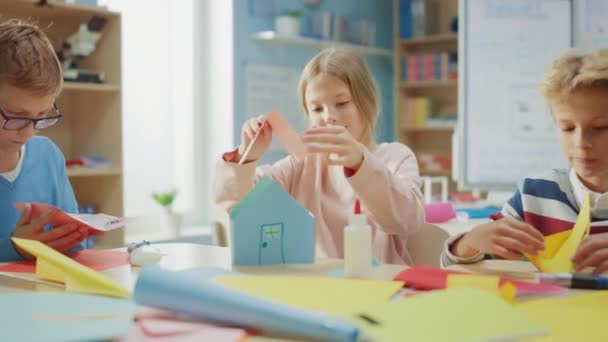 Elementary School Arts & Crafts Class: Diverse Group of Smart Children Have Fun on a Handicraft Project, Using Colorful Paper, Scissors and Glue to Build Papier Mache House. Zoom In Moving Camera — Stock Video