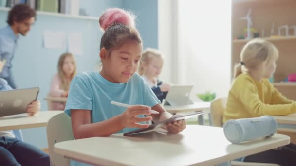 Элеонора Школа Наук Класс: Симпатичная девочка использует цифровые технологии, ее одноклассники тоже работают с топами. Дети, получающие современное образование в области STEM, игр и обучения — стоковое видео