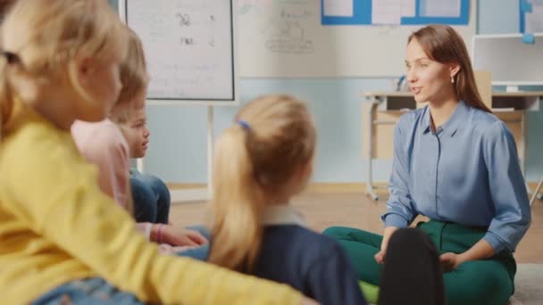 Clase de creatividad escolar: Los niños sentados en las bolsas de frijoles mientras cuidan al maestro explican la lección mientras usan la computadora digital de la tableta. Smart Children Learning in Friendly Modern Environment (en inglés). Moción lenta — Vídeos de Stock