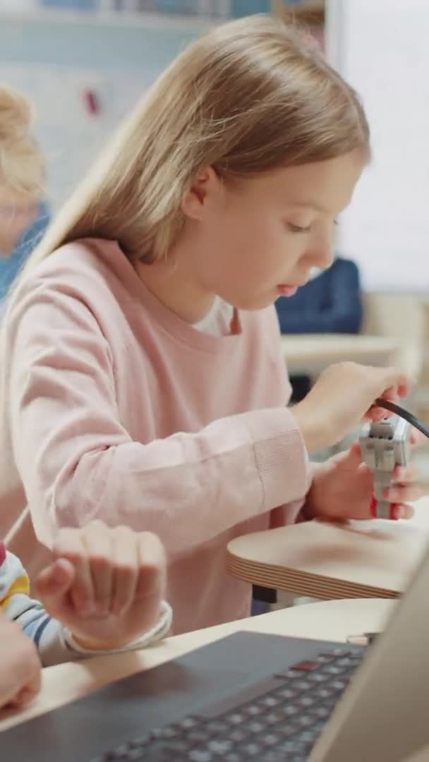 Elementary School Robotics Classroom: Portrait von Mädchen und Jungen im Gespräch während der Verwendung von Computer, Montage von Robotern, Programmiersoftware, Codierung. Videoaufnahmen mit vertikaler Bildschirmorientierung 9: 16 — Stockvideo