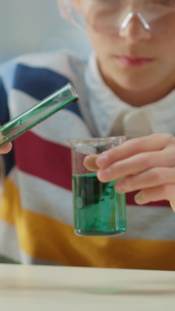 Cute Little Boy in Chemistry Class Mixes Chemicals and Beakers, Learning more about Science. Видео с вертикальным экраном Ориентация 9: 18 — стоковое видео