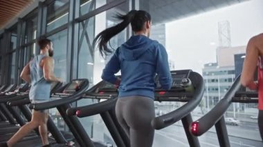 Koşu bandında koşan, spor yapan altı kişilik bir grup. Modern Spor Salonu 'nda Atletik, Kaslı Kadınlar ve Erkekler Etkin Eğitimdeler. Spor İnsanlar Antrenmanı. Geri Görünüm Yavaş Hareket Kamerası