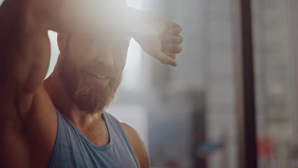 Portrait of Strong Bearded Male Athlete Wearing Sleeveless Shirt Wipes Sweat From His Forehead with His Muscular Hand. Handsome Man after Hardcore Exercise and Training. Man Gets Job Done — Stock Video
