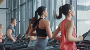 Koşu bandında koşan, spor yapan atletik insanlar. Modern Spor Salonu 'nda Atletik ve Kaslı Kadınlar ve Erkekler Aktif Eğitimdeler. Spor İnsanlar Antrenmanı. Yan Görünüm Kamerası Görüntüsü