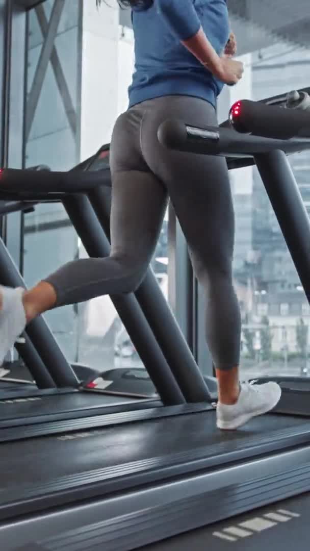 Piękna Sportowa Kobieta Biegająca na bieżni. Energiczny Fit Żeński trening atletyczny w siłowni. Trening sportowców w klubie fitness. Pionowe wideo orientacji ekranu 9: 16 — Wideo stockowe