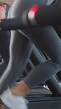 Koşu bandında Koşan Güzel Spor Kadını Kablosuz Kulaklık Kullanıyor. Spor salonunda Fit Female Training. Yan Görünüm Yavaş Çekimde Yükselen Çekim. Dikey Ekran Yönlendirme Videosu 9: 16