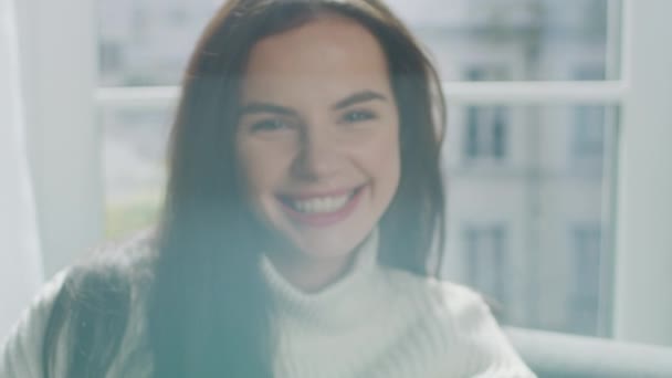 Portrait of Beautiful Young Brunette  Smiling Charmingly while Looking at Camera. Close-up of Gorgeous Sweet Girl Wearing White Knitted Sweater, Laughing Happily in Cozy Environment — Stock Video