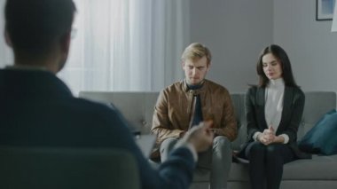 Psikoterapistle danışmanlık seansında bir çift. Not Tutan ve Konuşan Terapistin Arkasına Odaklan: Analizci Koltuğa Oturan, Psikolojik ve İlişki Sorunlarını Konuşan İnsanlar