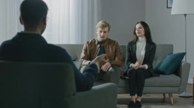 Psikoterapistle danışmanlık seansında olan genç bir çift. Terapistin Not Almasına Geri Bakış: Analizci Kanepede oturan Genç İnsanlar, Psikolojik Sorunlar ve İlişki Sorunlarını Tartışıyor