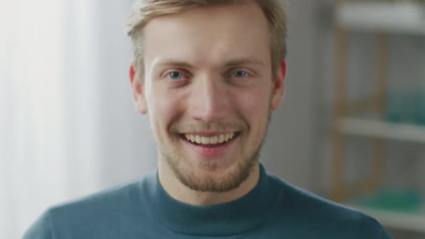 Portrait de beau jeune homme blond souriant, tout en regardant la caméra. heureux attrayant gars avec les yeux bleus — Video