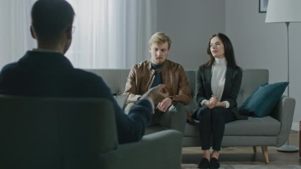 Jeune couple en séance de counseling avec un psychothérapeute. Précédent View of Therapist Taking Notes : Young People Sitting on the Analyst Couch, Discussing Psychological Issues and Relationship Problems — Video