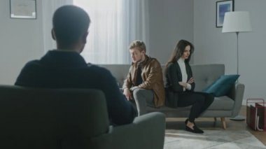 Psikoterapistle danışmanlık seansında olan genç bir çift. Terapistin Not Almasına Bakış: Analizci Koltukta Sırtüstü Oturan Gençler, Tartışma, Kavga, İlişki Sorunları