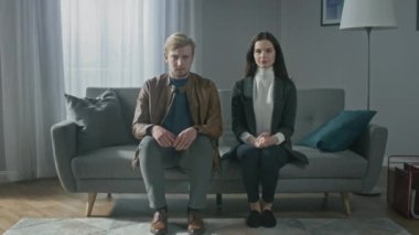 Terapistle Danışmanlık Seansında Üzgün Genç Çiftin Portresi. Kanepede oturup, kameraya bakıp konuşmak. Partnerler Psikolojik ve İlişki Sorunlarını, Cinsel Sorunları Tartışıyor