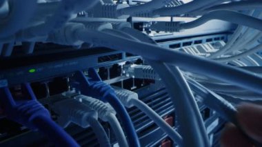 Bilgi İşlem Yöneticisi RJ45 Internet Connector 'ı LAN Router Switch' e bağlıyor. Veri Merkezi 'ndeki Bilgi İletişim Ağı ile Yanıp sönen Işıklarla Modem Portlarına Bağlı Kablolar