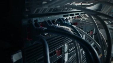 Bilgi İşlem Yöneticisi RJ45 Internet Connector 'ı LAN Router Switch' e bağlıyor. Veri Merkezi 'ndeki Bilgi İletişim Ağı ile Yanıp sönen Işıklarla Modem Portlarına Bağlı Kablolar