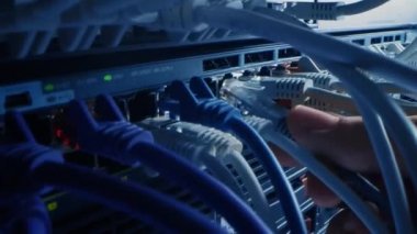 Bilgi İşlem Yöneticisi RJ45 Internet Connector 'ı LAN Router Switch' e bağlıyor. Veri Merkezi 'ndeki Bilgi İletişim Ağı ile Yanıp sönen Işıklarla Modem Portlarına Bağlı Kablolar