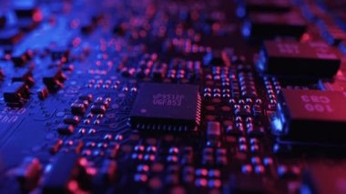 Mikroçip ve işlemciye odaklan. Yazdırılmış devre kartı / Bileşenli bilgisayar ana kartı: Elektronik Aygıtın İçinde. Neon Renkleri. Siber Güvenlik Konsepti. Döndürme Makro Vuruşu