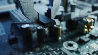 Çalışan Fabrika Makinesi: Yazdırılmış devre tahtası Robotik Kol, Yüzey Bağlı Teknoloji Mikroçipleri, İşlemci Anakart 'a bağlanıyor. Makro Yakın Çekim Odaklanıyor