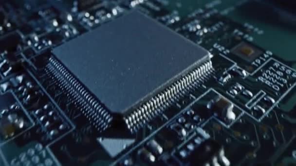 Makrokamera bewegt sich langsam über Leiterplatte, zeigt Computer-Motherboard-Komponenten: Mikrochip, CPU-Prozessor, Transistoren. Im Inneren von elektronischen Geräten. Bild wird erhellter — Stockvideo