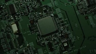 Mikroçip ve işlemciye odaklan. Yeşil Yazdırılmış Devre Panosu, Bileşenli Bilgisayar Anakart: Elektronik Aygıtın İçinde, Süper Bilgisayarın Bir Parçası. Dönen Üst Görünüm İzleme Makro Görüntüsü