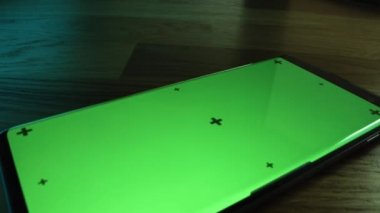 Modern Smartphone 'un üzerinde uçan kamerayla yakın plan makro çekim. Yeşil Model Ekran açık. Chroma Key Ekranlı Cep Telefonu. Kolay Kullanım için Hareket İzleme Noktaları.