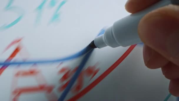 Makroaufnahme eines blauen Marker-Stifts, der mit einer Hand gehalten wird. Person, die Grafiken auf einem Whiteboard zeichnet. Bleistift wird mit der Kamera verbunden. Ergriffener Schuss. Skizzieren mit Fineliner. — Stockvideo