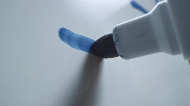 Mavi İşaretli Kalem Elle Tutulurken Makro Takip Çekimi. Grafikli bir Whiteboard 'a 