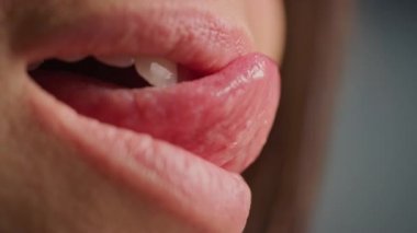 Üç Çeyrek Dolarlık Makro Shot Kusursuz Beyaz Dişli Bir Ağız. Dişi, dolgun dudakları seksi bir şekilde yalıyor. Güzel Doğal Sağlıklı Kırmızı Dudaklı ve Güzel Gülümseyen Dişli Kadın.