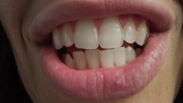 매크로 샷의 완벽 한 흰색 이빨로 입을 닫으세요. 말하는 사람 과 말하는 사람은 입 과 혀의 움직임을 본다. 귀여운 자연 건강 한 붉은 입술을 가진 암컷 과예쁜 미소를 띤 치아까지 있는 암컷. — 비디오