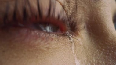 Ağlayan Göz 'ün Macro Zoom Çekimi' ni kapat. İris 'te Doğal Açık Mavi, Sarı ve Kahverengi Pigmentasyonlu Genç Güzel Kadın. Mascara kirpiklere uygulanır. Gözyaşları akıyor.