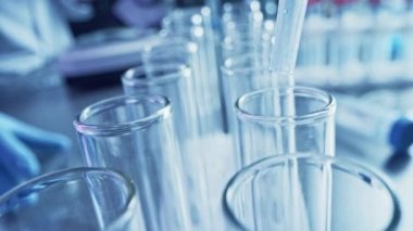 Bilimsel Laboratuvar: Pipette Sıvıyı Test Tüplerine Bırakıyor, Tıbbi Araştırma ve Analiz. Taşıyıcı İlaç Üretim Hattı; Damlatıcı DNA Çalışması için kullanılan örnek tüpleri doldurur. Makro 'yu yakın plan