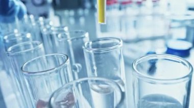 İlaç Laboratuvarı, Pipette Damlayan Sarı Sıvı Test Tüpleri, Tıbbi Araştırma, Analiz. Bilimsel Laboratuvar; Damlatan, Örnek Tüpleri Yenilikçi DNA Çalışması Çözümü ile Dolduruyor. Makro 'yu yakın plan