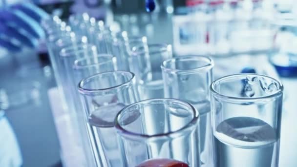 Pharmaceutics Laboratory: Pipette kapání modré kapaliny do zkumavky, Lékařský výzkum, Analýza. Vědecká laboratoř; Kapátko plní zkumavky s inovativním DNA řešení studie. Detailní makro — Stock video